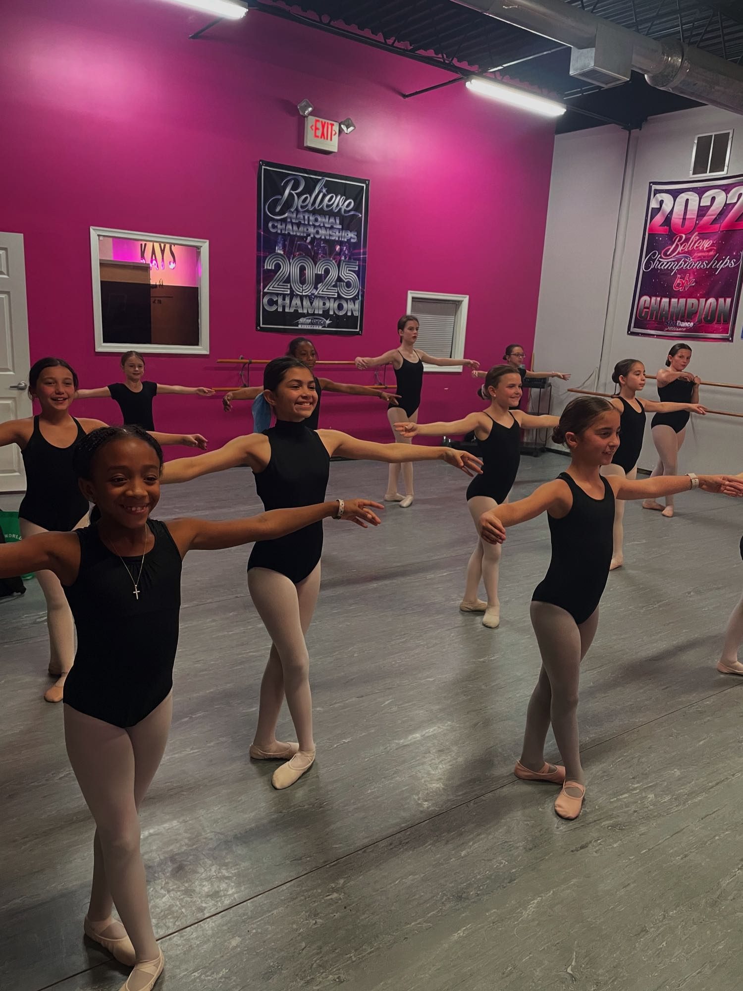 Ballet class at the barre at Kay's Act II, national championship banners on the wall